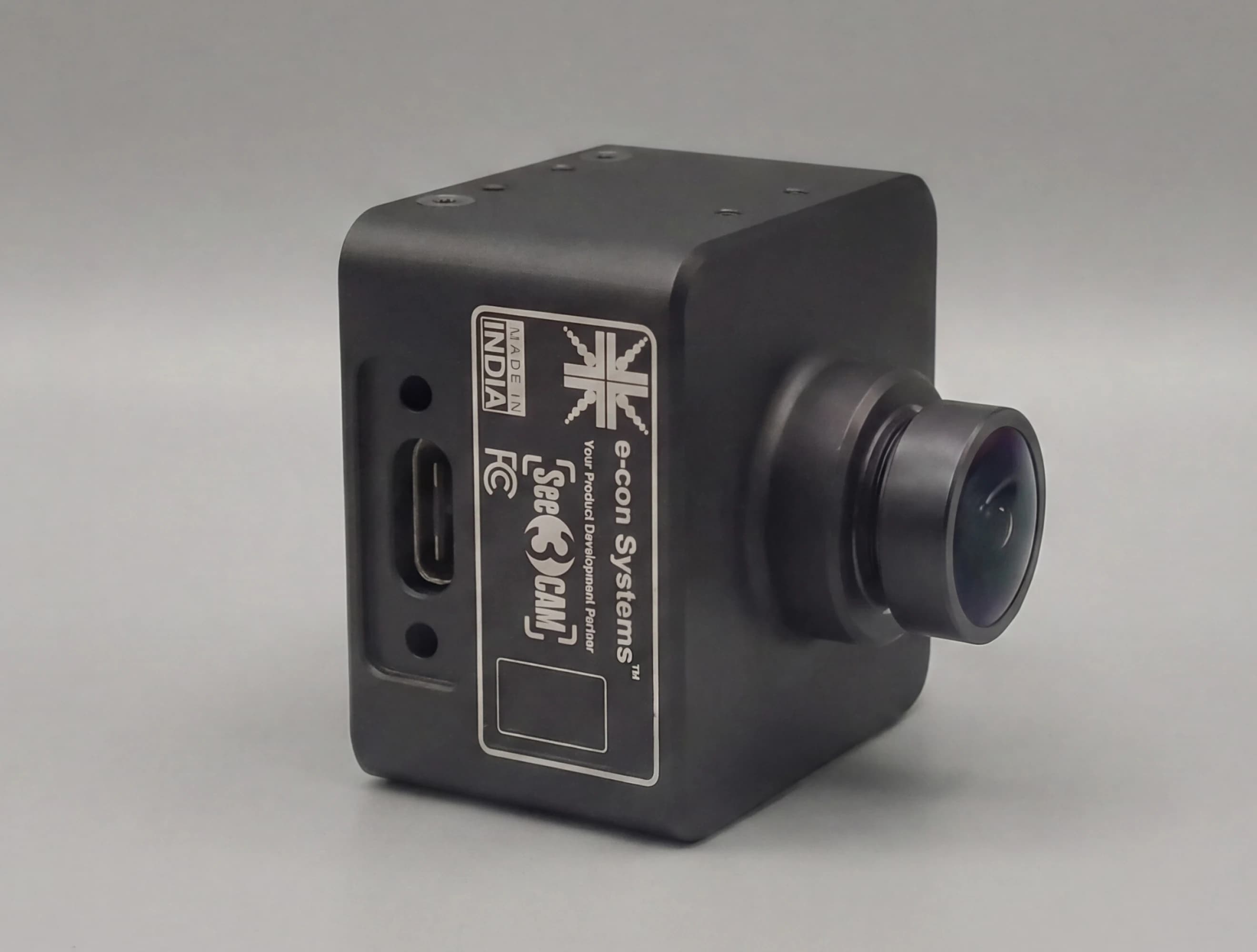 Black e-con Systems camera with wide-angle lens and visible USB port, showcasing "Made in India" and brand logos.