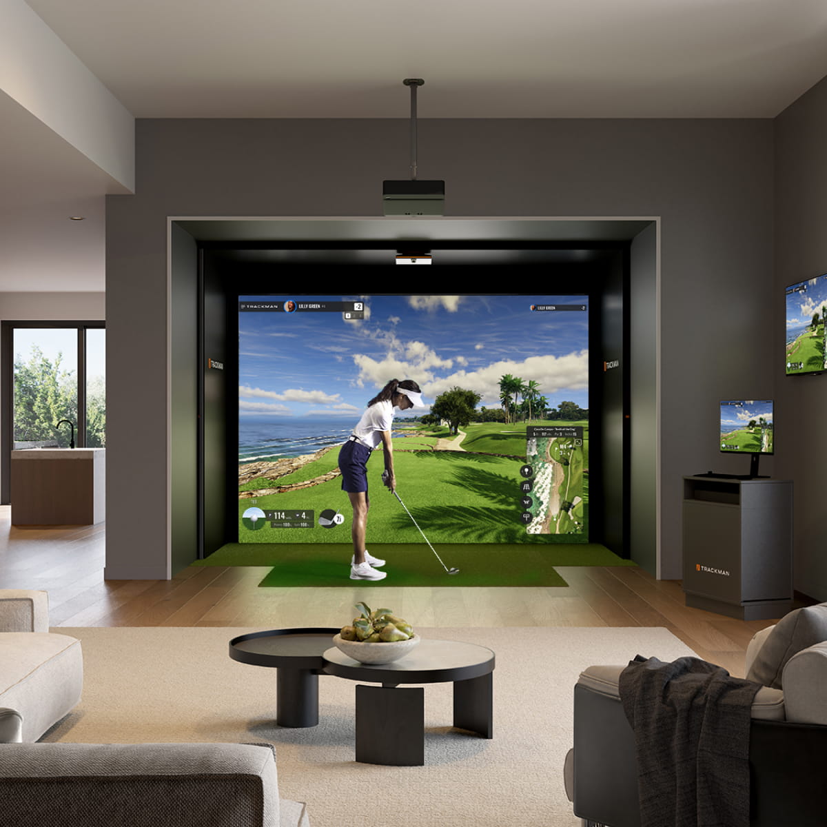 モダンなリビングルームで、Trackman 屋内ゴルフ シミュレーターを使ってゴルフをする女性。