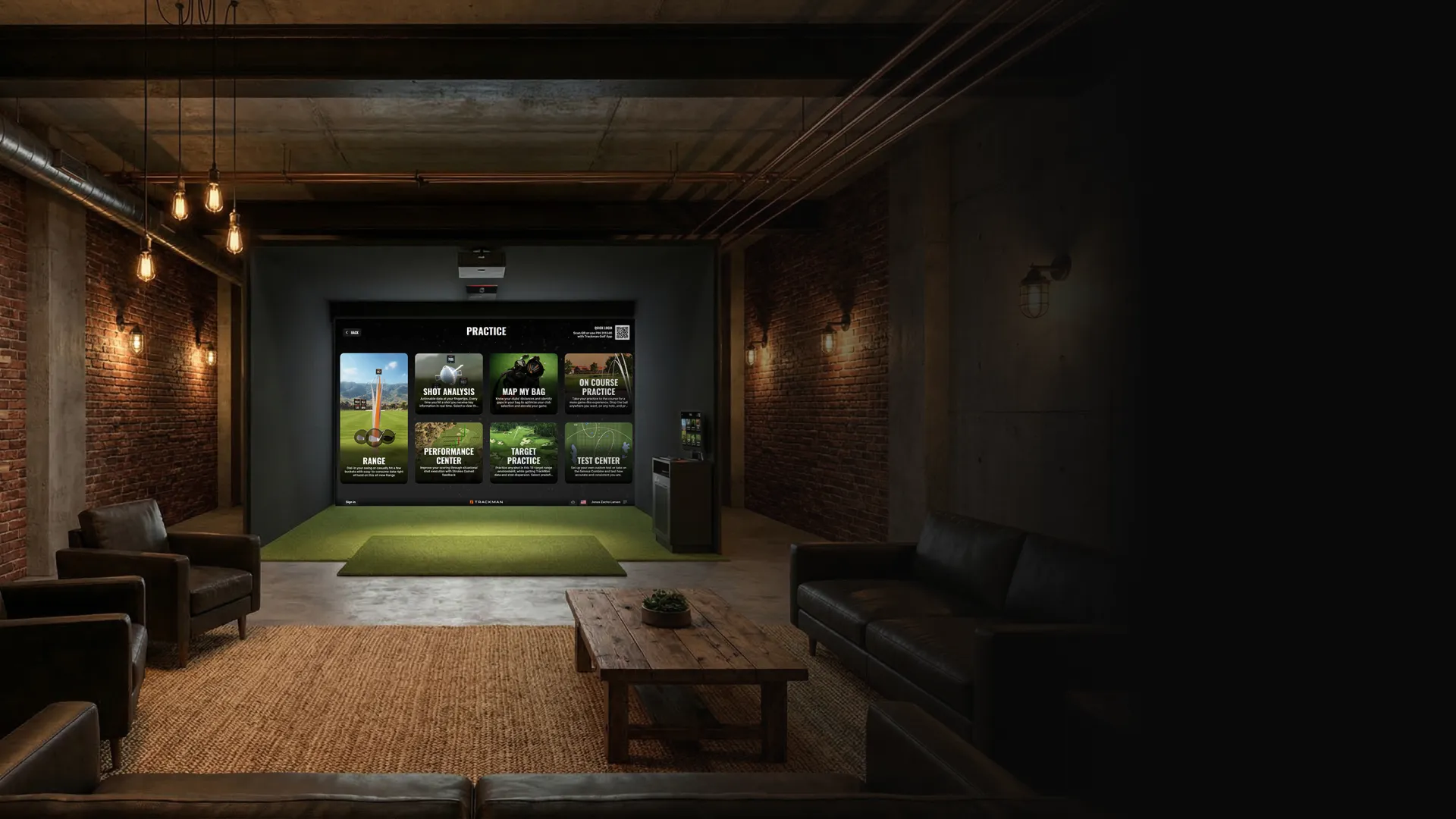 A modern indoor golf simulator room with a large practice screen, sofas, and industrial lighting, creating a cozy atmosphere.